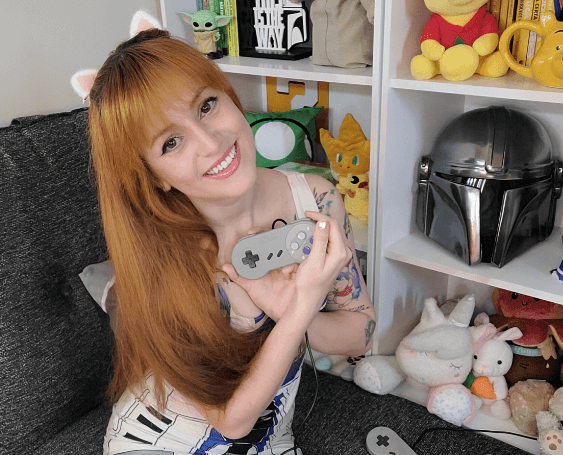 Playful gamer girl Mia Lorenzi surrounded by collectibles